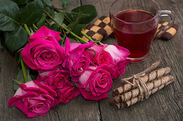 一束红玫瑰，饼干和咖啡，放在一张木桌上，静物