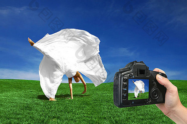 用数码相机拍摄新娘在草地上打车的照片