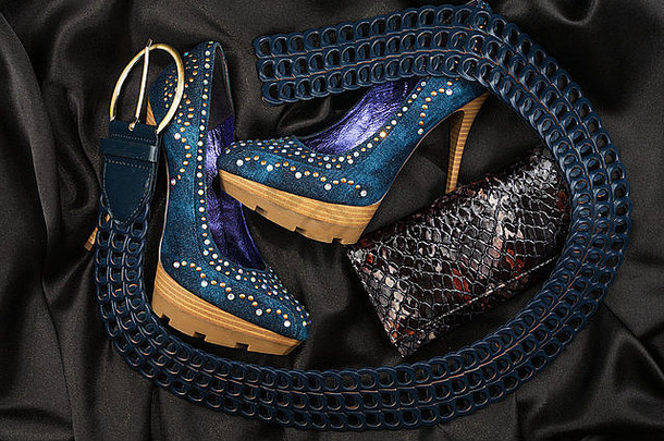蓝色的鞋子和腰带，黑色缎子上的钱包，作为背景