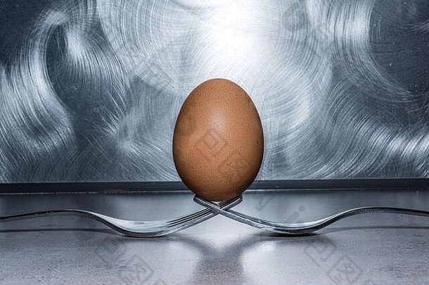 两个叉子上的鸡蛋，不锈钢刷背景