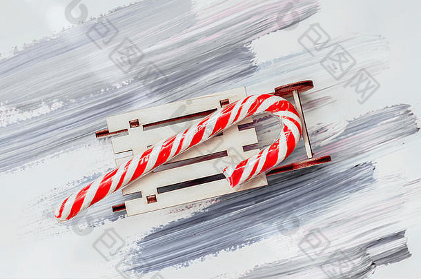 传统的圣诞棒棒糖，小木雪橇上的糖果。节日圣诞背景