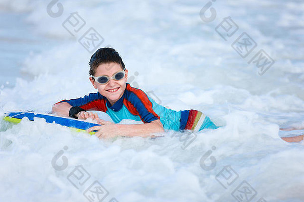 度假的小男孩在布吉板上游泳玩得很开心