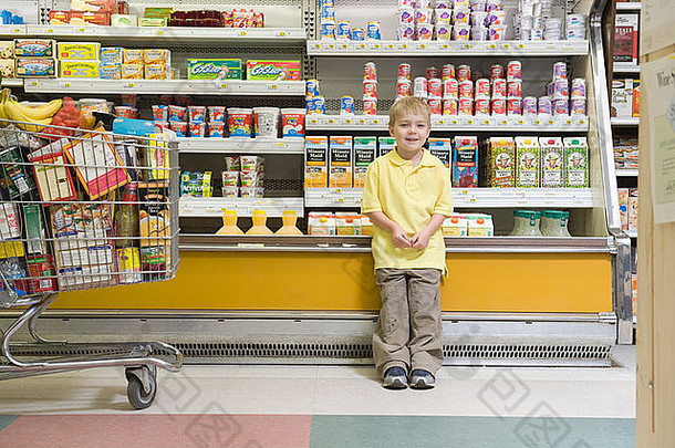站在超市冰<strong>箱柜</strong>台旁的小男孩