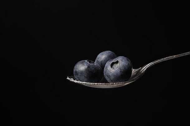 勺子蓝莓孤立的黑色的背景