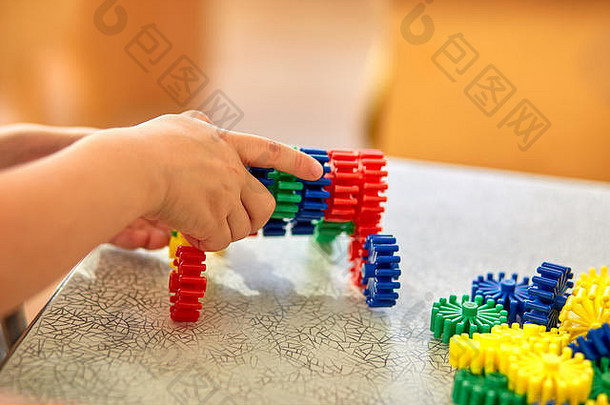 一个男孩在桌上收集一个软拼图。学龄前儿童和教育玩具