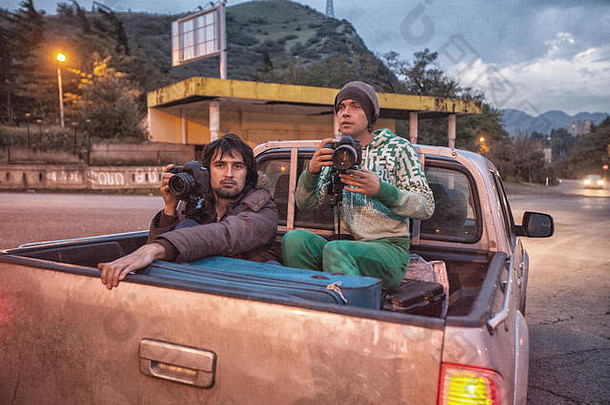 在乔治亚州，卡车上的两名摄影师和游客拿着相机