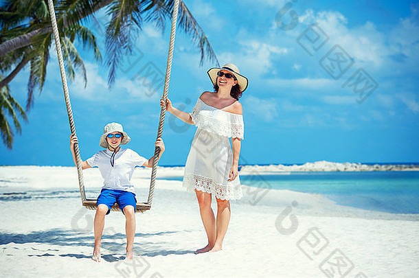 年轻的美丽的女人摆动儿子热带海滩KOHPhangan岛泰国