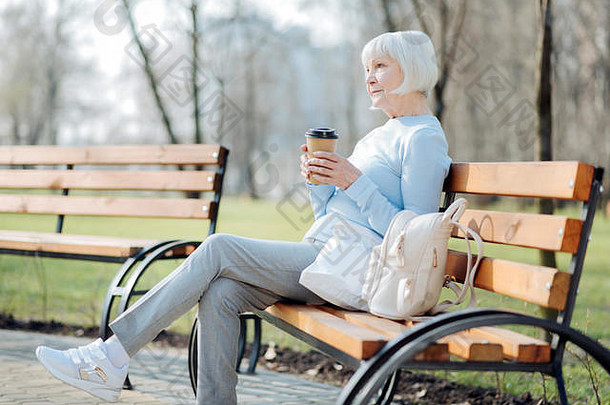 放松女人喝咖啡坐着板凳上