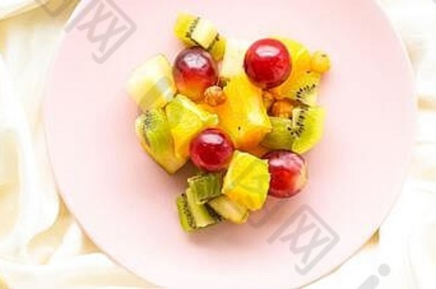 新鲜的有机水果沙拉粉红色的板健康的营养排毒饮食计划平躺