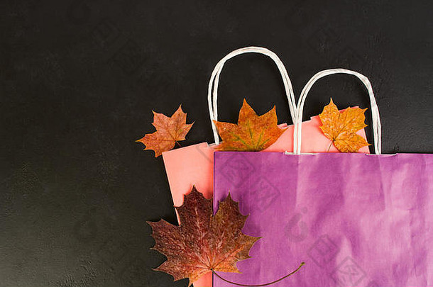 购物纸袋干秋天叶子黑色的背景复制空间平躺风格