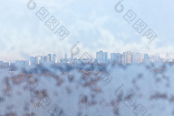 寒冷冬日透过冰雪覆盖的窗户看城市房屋