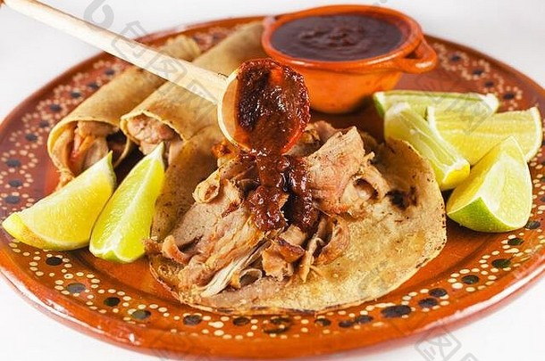 墨西哥卡尼塔斯玉米卷是墨西哥城传统的<strong>猪肉</strong>玉米卷，以白色为背景，配以玉米饼和酱汁