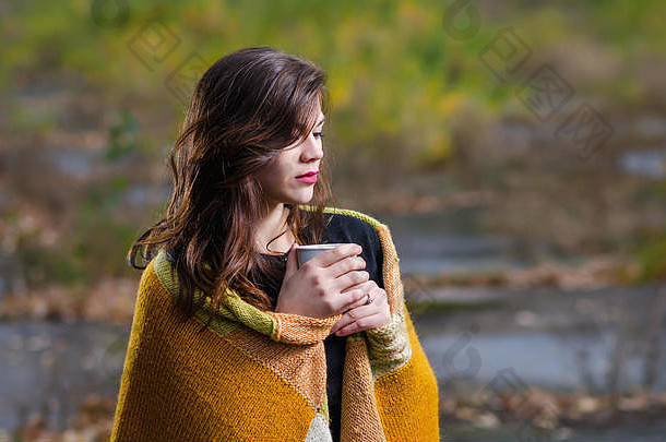 <strong>秋天</strong>的傍晚，年轻漂亮的女孩裹着毛毯，手里拿着一<strong>杯</strong>咖啡（茶）。