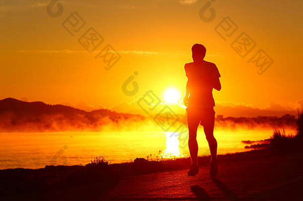 跑步者剪影，在温暖的背景下，在日落时在海滩上跑步
