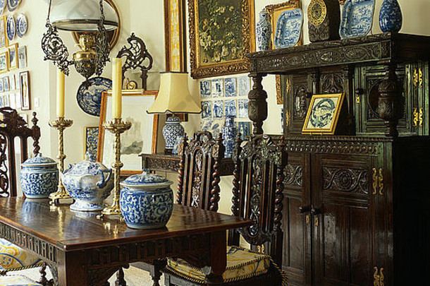 乡村餐厅的蓝 白瓷器系列，配有重型雕刻橡木桌子、餐具柜和雅各布风格的椅子