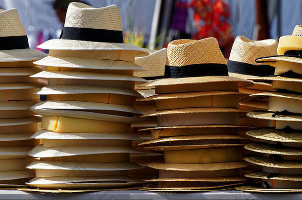 阳光明媚的日子里，市场摊位上堆满了草帽