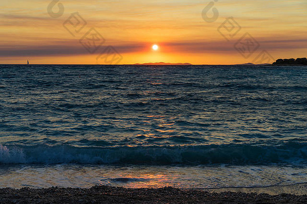 克罗地亚普里莫斯顿亚得里亚海美丽的日落。在海滩度过一个温暖的夏日夜晚。五彩缤纷的天空和水。美好、平静、平和的形象。