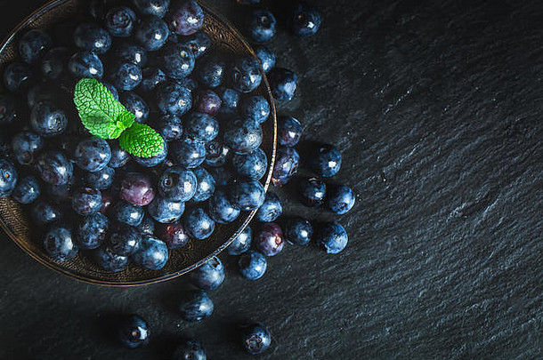 乡村餐桌上绿叶的多汁新鲜蓝莓。蓝莓抗氧化剂。健康饮食和营养的概念。水平的出身背景