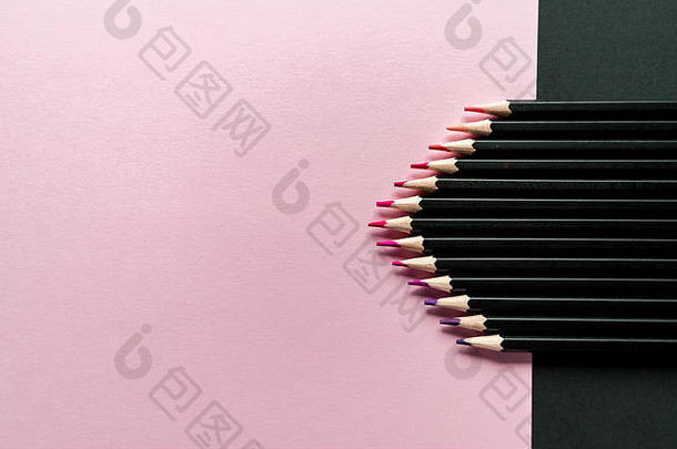 粉红色和黑色背景上的彩色铅笔