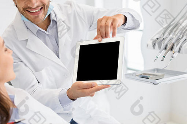 显示空白数字平板电脑屏幕的牙医裁剪图像