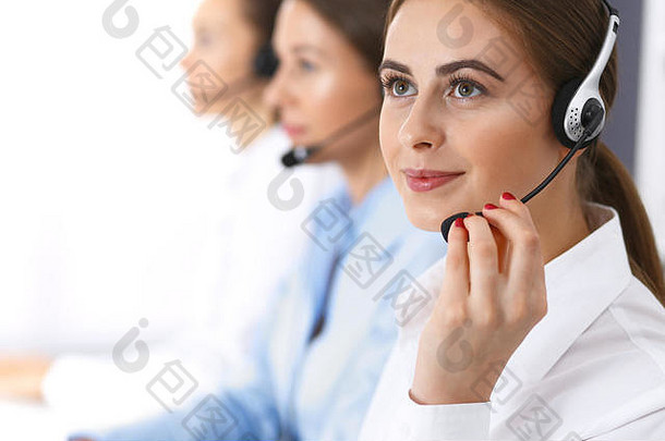 呼叫中心。一组正在工作的操作员。关注戴耳机的美丽女商人