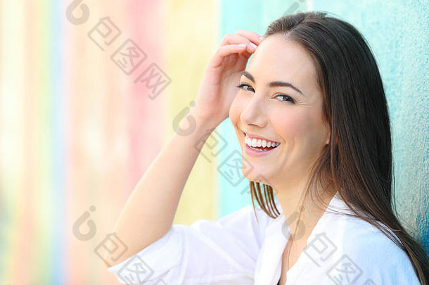 快乐女人完美的微笑摆姿势相机色彩斑斓的背景