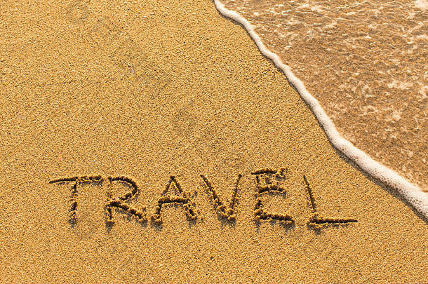 旅行-手写在沙滩上的海浪线。