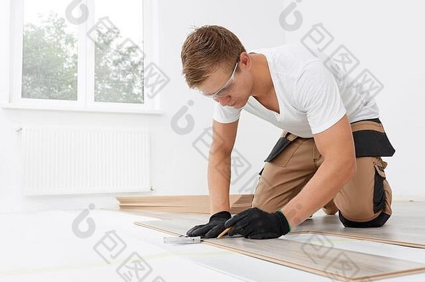 安装层压板木条镶花之地板房间工人安装木层压板地板标记长度层压板