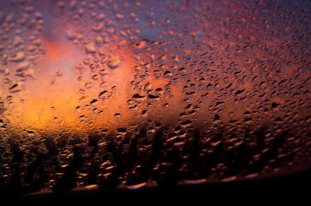 落日背景下窗户上的水滴