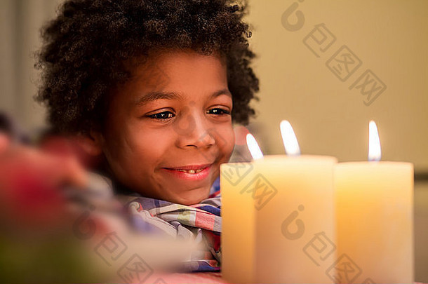 圣诞蜡烛旁的快乐孩子。