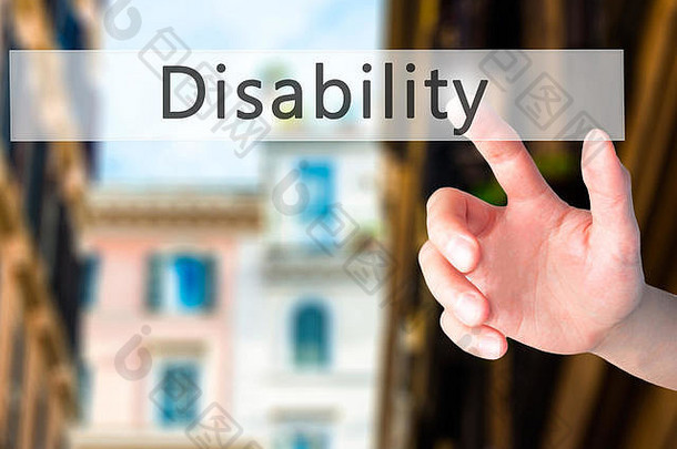 残疾-用手按下模糊背景上的按钮。商业、技术、互联网概念。库存照片
