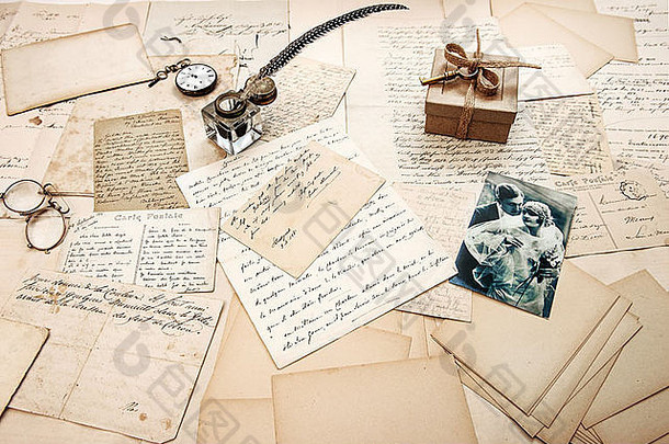 旧信件，老式明信片和古董羽毛笔。怀旧的情感背景与复古的情侣照片