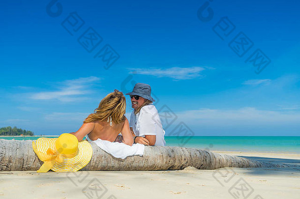 马尔代夫热带海滩上的一对情侣坐在一起