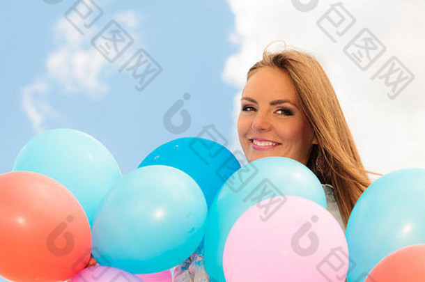 夏天假期庆祝活动生活方式概念特写镜头美丽的女人青少年女孩色彩斑斓的气球蓝色的天空背景