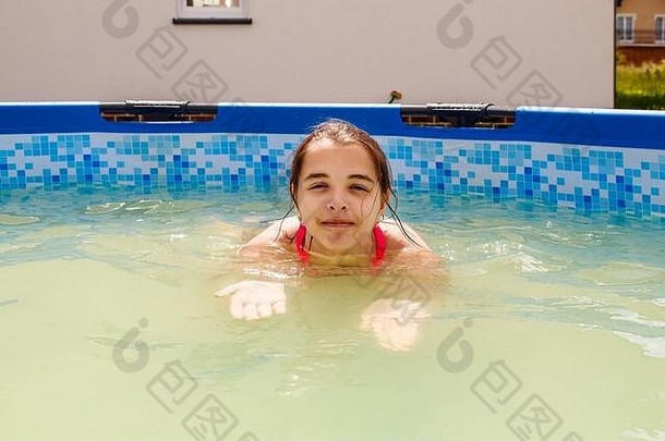 在阳光明媚的<strong>夏日</strong>，一个十几岁的女孩正在她家附近的一个小<strong>游泳</strong>池里<strong>游泳</strong>