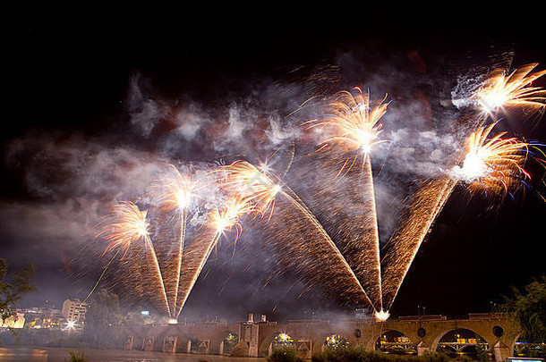 在圣胡安的节日之夜，西班牙巴达霍兹的普恩特·德·帕尔马斯桥燃放了五颜六色的焰火