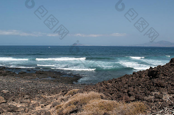 富尔特文图拉，大西洋，北非，西班牙：从洛沃斯小岛上看到的<strong>岩石</strong>，海浪和兰扎罗特的景色