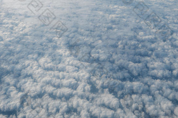 美丽的云景和清澈的蓝天。透过飞机窗口看到的白云上方的全景。从飞机窗口看到的景色