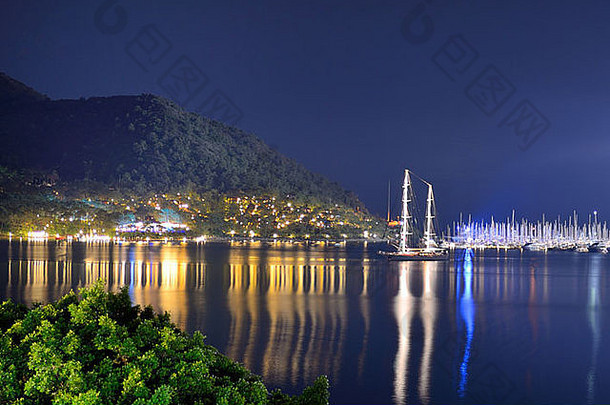 土耳其马尔马里斯，夜晚灯光下码头和海滩上的游艇