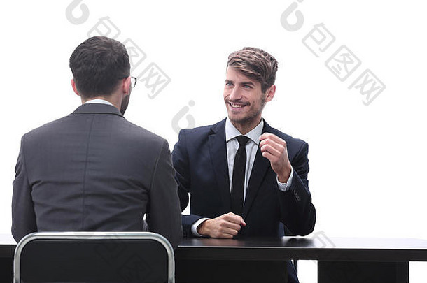 两个商务人士坐在办公桌旁聊天