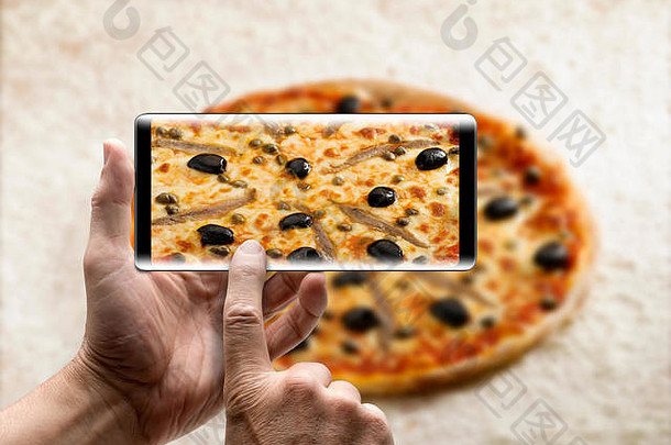 手持有移动智能手机图片美味的披萨