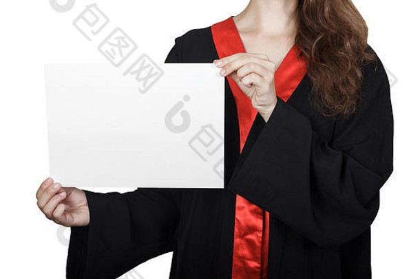 女研究生从一块空白板后面偷看。身着毕业礼服的快乐女孩的肖像，白色背景上有标语牌。