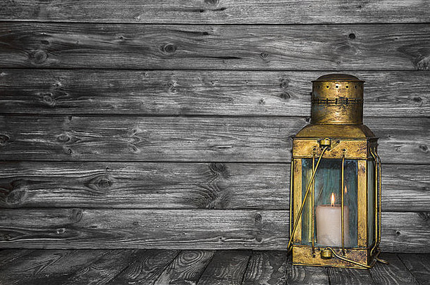 旧古朴的金色铜灯，以木质破旧的背景为概念。