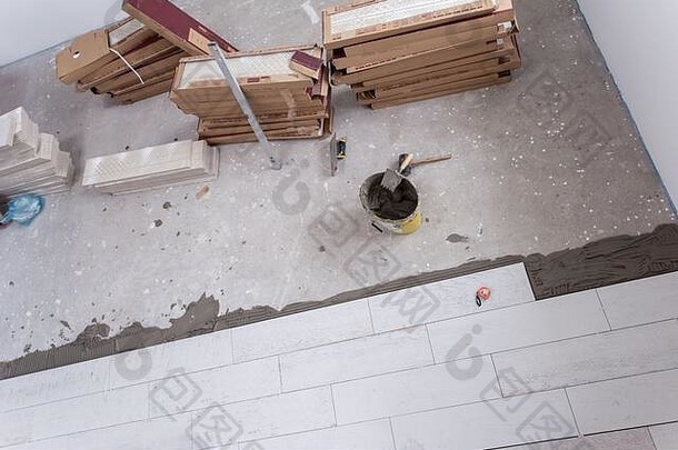 地板上的瓷砖和工具未完工铺设<strong>地板砖地板砖</strong>