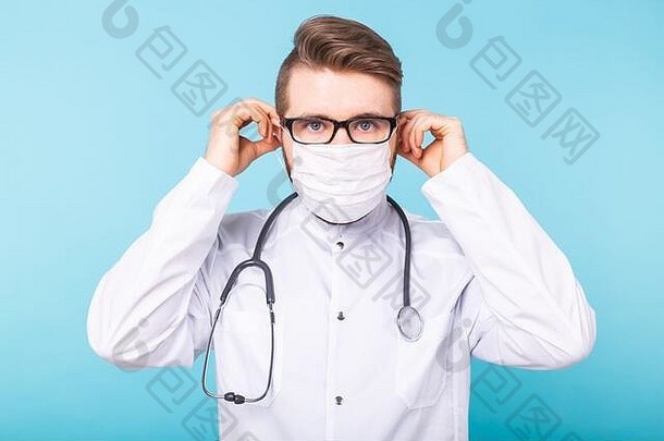 男医生戴上蓝色背景的医用面罩。冠状病毒2019冠状病毒疾病流行概念