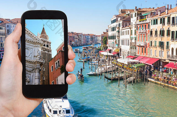 旅游理念-游客通过智能手机拍摄意大利威尼斯城的建筑