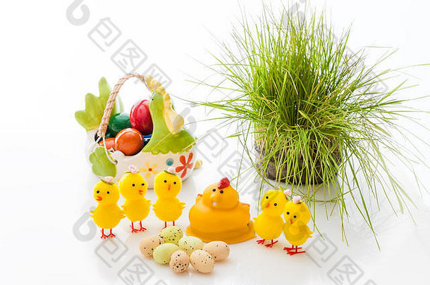 黄色复活节小鸡和篮子陶瓷复活节彩蛋，背景为浅色。空间。