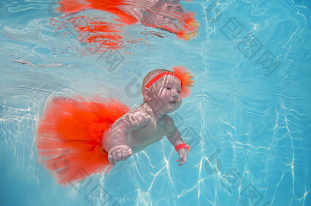 一个穿着公主装的小女孩正在游泳池的水下游泳