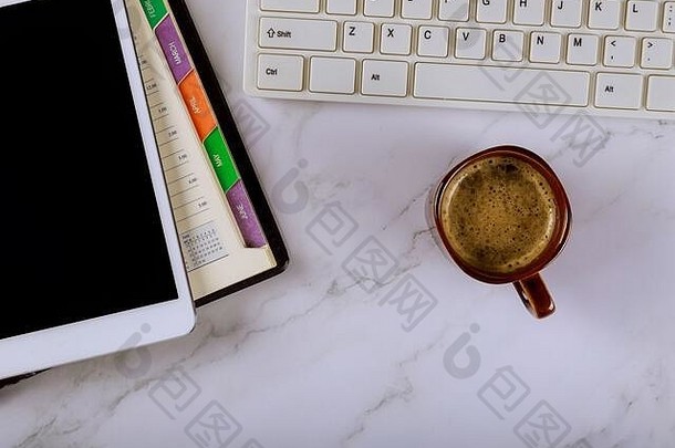 组织管理规划师带键盘的每周日历杯咖啡和数字平板电脑业务团队