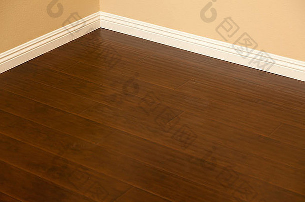 漂亮的新的棕色强化木地板和家中的踢脚板。